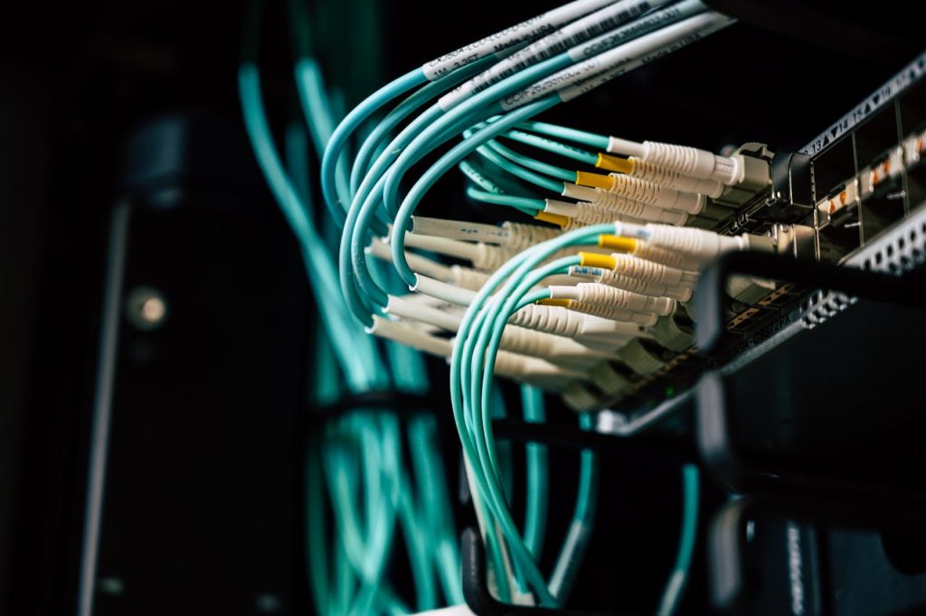 cables-connected-on-server-2881229 Detailed view of network cables plugged into a server rack in a data center.