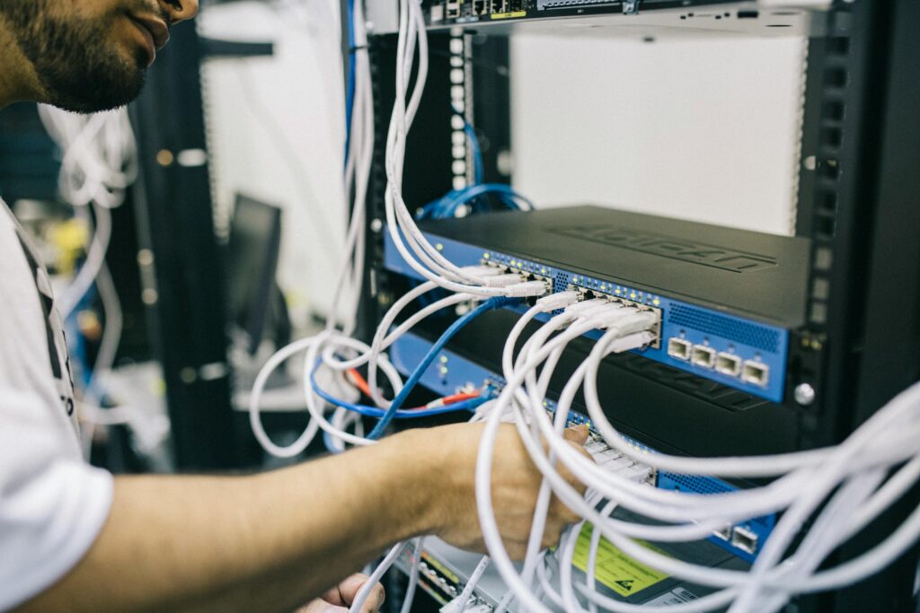 Maintenance réseau sur site – EntreprisePro Technicien informatique effectuant une maintenance sur un rack réseau